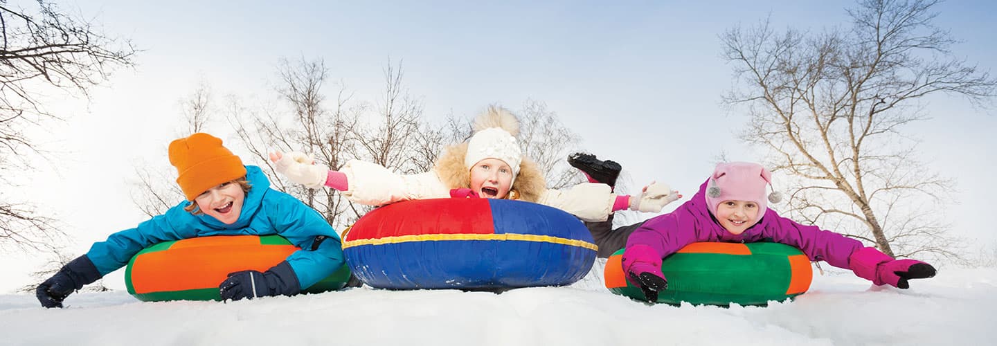 Three kids snow tubing