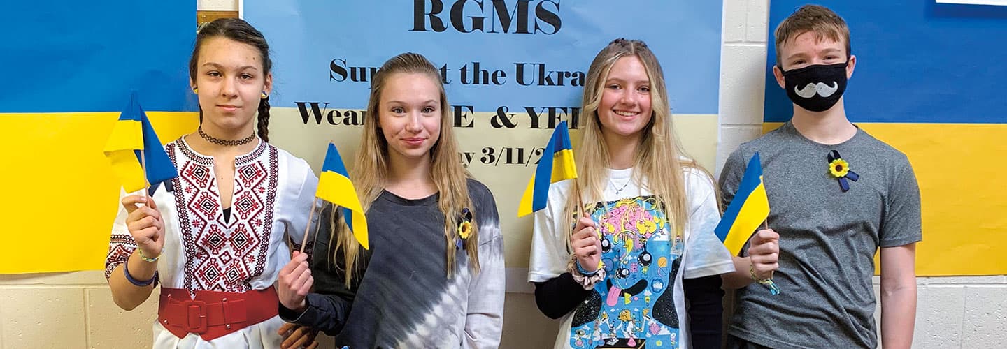 Four students hold Ukrainian flags