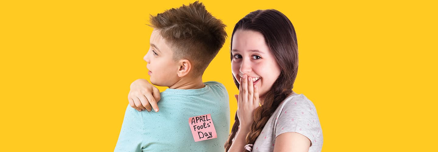 Image of one friend putting an 'April's Fool Day' note on someone's back